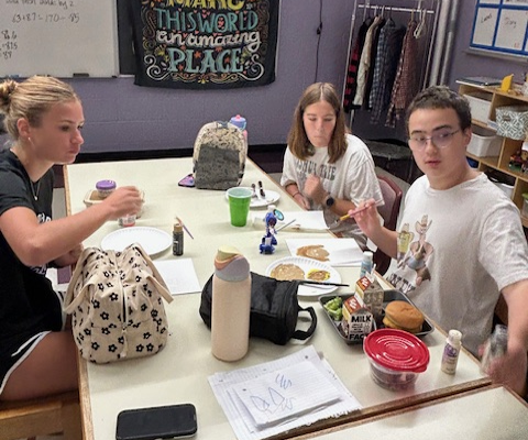 Shelby Patten and Alyie Roth paint with Lucas Ellis during their Titan Buddies lunch. 